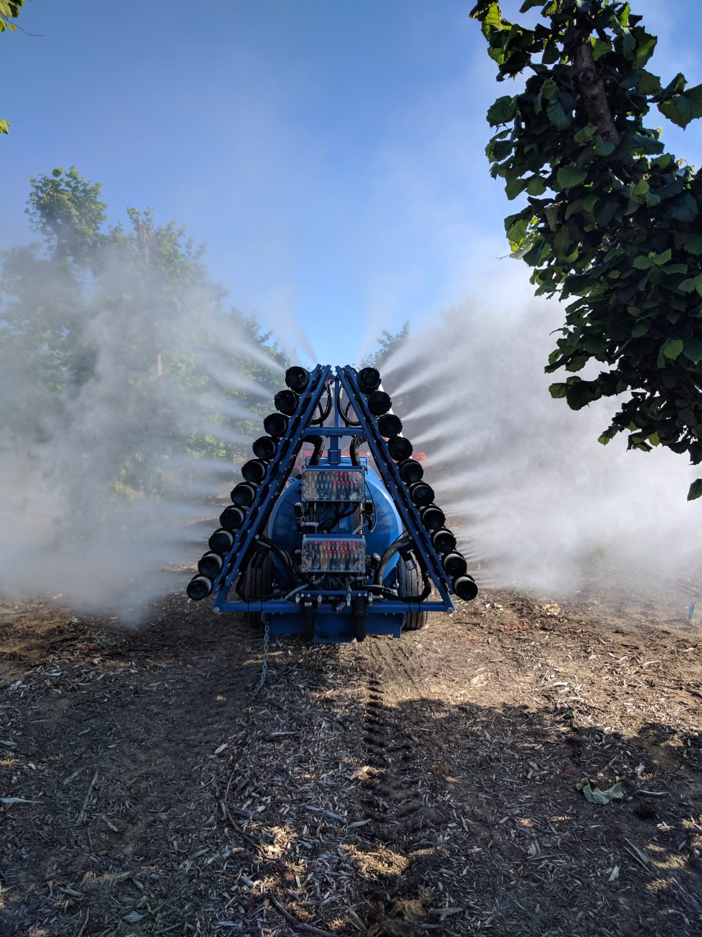 OnTarget electrostatic sprayer running through a hazelnut orchard